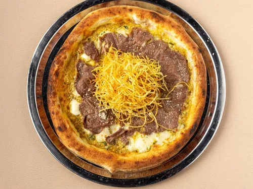 Paris Soslu Biftekli — Dana bonfile dilimleri, parmesan, özel Paris sosu, mozzarella, taze roka ve çıtır patates.